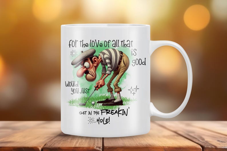 May include: White ceramic coffee mug with a cartoon golfer illustration and the text "for the love of all that is good would you just get in the freakin' hole!"