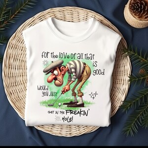 May include: White t-shirt with a cartoon golfer and the text "for the love of all that is good. Would you just get in the freakin' hole!"