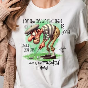 May include: White t-shirt with a cartoon golfer and the text "for the love of all that is good, would you just get in the freakin' hole!"