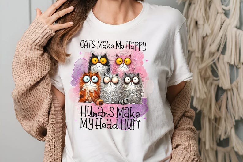 May include: White t-shirt with a graphic of four cartoon cats and the text "Cats Make Me Happy Humans Make My Head Hurt".