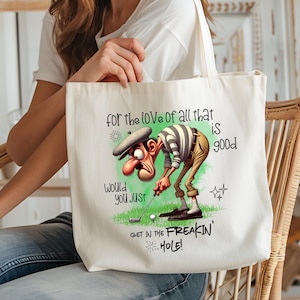 May include: White canvas tote bag with a cartoon golfer illustration and the text "for the love of all that is good, would you just get in the freakin' hole!"