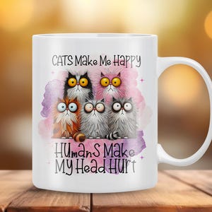 May include: White ceramic mug with a colorful illustration of five cats and the text "Cats Make Me Happy Humans Make My Head Hurt".