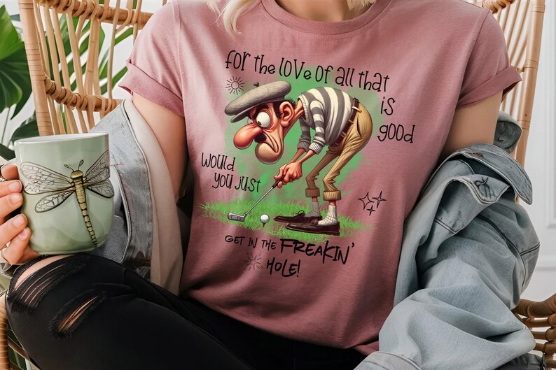 May include: A pink t-shirt with a cartoon golfer and the text "for the love of all that is good would you just get in the freakin' hole!"