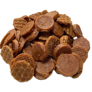 May include: A pile of brown, circular dog treats with various textures. Some treats are round, others are rectangular, and some have a waffle-like pattern. The treats are a medium brown color and appear to be crunchy.
