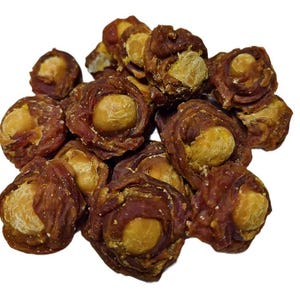 May include: A pile of dog treats, each featuring a light brown center surrounded by a darker brown, textured outer layer. The treats are clustered together against a white background, showcasing their individual shapes and textures.