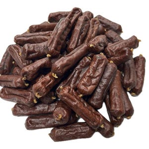 May include: A pile of dark brown sausages with a slightly wrinkled texture. Each sausage is individually wrapped at both ends. The sausages are tightly packed together, creating a dense arrangement against a white background.