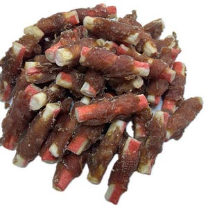 May include: A pile of dog treats. The treats are a dark brown color, with a red and white center. The treats are wrapped in a spiral shape.