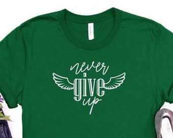 May include: A green t-shirt with white text that reads "never give up" with wings on either side of the word "give".