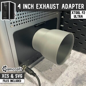 Può includere: Un adattatore di scarico grigio da 10 cm fissato a una macchina. Il testo "4 INCH EXHAUST ADAPTER" è in alto. Il testo "XTOOL F2 ULTRA" è a destra. Il testo "Samcraft XCS & SVG FILES INCLUDED" è in basso.