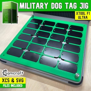 Op de afbeelding: Een felgroene kunststof mal voor een xTool F1 Ultra lasermachine, voorzien van een raster met vierentwintig rechthoekige sleuven waarin zwarte metalen militaire naamplaatjes zijn geplaatst. De tekst MILITARY DOG TAG JIG, XTOOL F1 ULTRA, Samcraft en XCS & SVG FILES INCLUDED is zichtbaar.