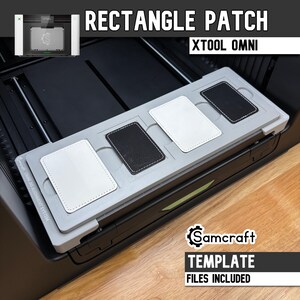 Puede incluir: Un sistema de alineación de plantilla Samcraft Omni gris para la máquina láser xTool Omni, con cuatro ranuras para parches rectangulares. Dos parches blancos y dos negros con bordes cosidos están colocados en las ranuras. El texto dice RECTANGLE PATCH, XTOOL OMNI, Samcraft y TEMPLATE FILES INCLUDED.