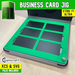 May include: A business card jig with a green frame and black inserts, designed for the XTOOL F1 ULTRA. The jig includes the text "BUSINESS CARD JIG" and "XCS & SVG FILES INCLUDED". The Samcraft logo is also visible.