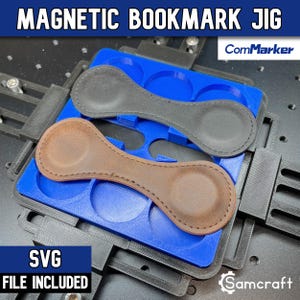 Puede incluir: Un juego de marcapáginas magnéticos de cuero negro y marrón sobre una plantilla azul impresa en 3D con marco negro. El texto dice MAGNETIC BOOKMARK JIG, ComMarker y SVG FILE INCLUDED. La plantilla tiene recortes circulares para sujetarlos.