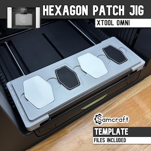 Puede incluir: Una plantilla de alineación de parches hexagonales Samcraft de color gris claro para la máquina láser xTool Omni. La plantilla rectangular cuenta con cuatro ranuras empotradas que sostienen parches hexagonales blancos y negros.