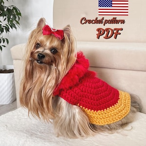 May include: A small dog with long, flowing brown and blonde hair, wearing a red crochet dog coat with a yellow trim and a red bow. The image includes the text "Crochet pattern PDF" and an American flag.