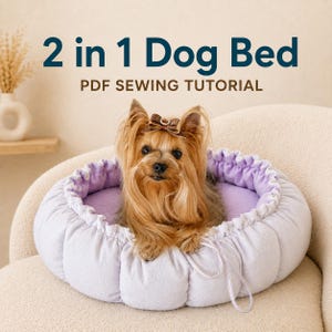 Peut inclure: Un tutoriel de couture PDF pour un lit pour chien 2 en 1, illustré par un petit chien brun à poils longs portant un nœud brun, assis dans un panier rond matelassé de couleur lavande claire avec un cordon de serrage et une doublure douce.