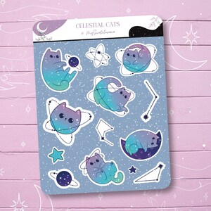 May include: A sticker sheet featuring celestial cat designs. The stickers showcase cats in various poses, with a gradient of blue, purple, and teal colors. The sheet includes stars, planets, and constellations. The text "Celestial Cats" is at the top.