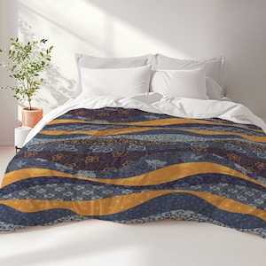 May include: A blue and gold patterned duvet cover with a wavy design. The duvet cover features a floral pattern and a geometric design.