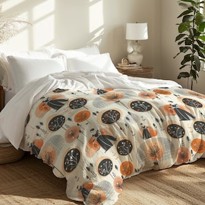 May include: A white duvet cover with a cream background and a repeating pattern of orange and grey stylised trees. The trees have black silhouettes of people standing in them.