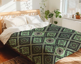 Könnte beinhalten: Ein grüner und schwarzer Bettwäschebezug mit geometrischem Muster. Der Bezug liegt auf einem Bett mit weißen Kissen.