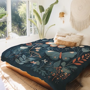 May include: A dark blue duvet cover with a floral and butterfly pattern. The pattern features orange, green, and white accents. The duvet cover is on a bed with white pillows and a brown throw pillow.