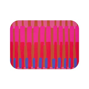 May include: A rectangular bath mat with a colourful abstract design. The mat features vertical stripes in shades of pink, orange, and blue.