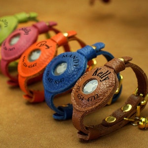 Può includere: Cinque collari per gatti in pelle colorati con targhette con nome e numeri di telefono incisi. Ogni collare è dotato di un piccolo campanello.