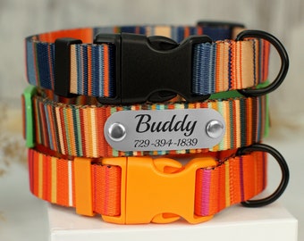 May include: Three colorful striped dog collars stacked on top of each other. The top collar is navy blue, orange, and tan. The middle collar has a silver nameplate that reads "Buddy" and a phone number. The bottom collar is orange and pink.