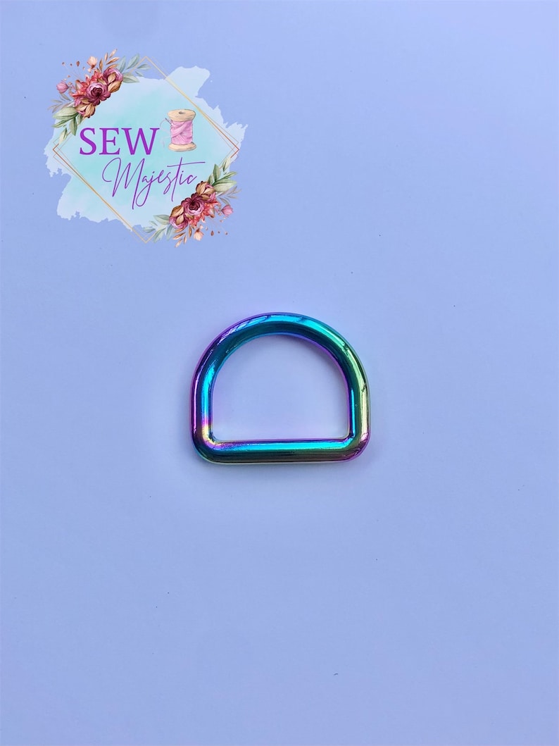 Puede incluir: Un anillo en D de metal iridiscente arco&iacute;ris. El anillo es de tama&ntilde;o est&aacute;ndar para sujetar a bolsos, correas u otros accesorios.