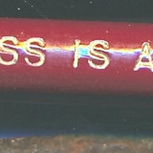 May include: A red, cylindrical object with white text that reads "N 22 SANTA FE TRENDINESS IS A TRADITION".