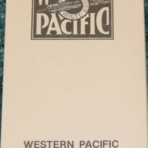May include: A tan-colored notepad with the Western Pacific Railroad logo and the text "Western Pacific Railroad Efficiency Tests".