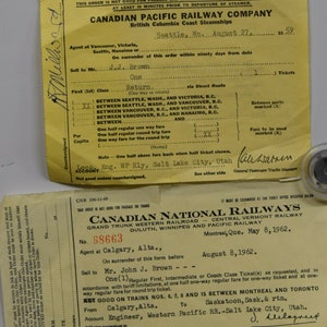 May include: Two vintage train tickets. The top ticket is yellow and reads "Canadian Pacific Railway Company" with the text "Seattle, Wa. August 27, 1959." The bottom ticket is white and reads "Canadian National Railways" with the text "Montreal, Que. May 8, 1962."