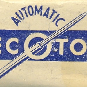 Peut inclure: Boîte vintage avec le mot "AUTOMATIC" en arc au-dessus d'un rectangle bleu avec le mot "RECOTON" en blanc. Un motif en forme d'aiguille blanc et bleu est centré sur la boîte. Le fond est beige délavé.