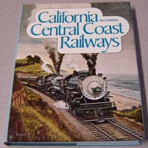 May include: A hardcover book titled "California Central Coast Railways" featuring a vintage train on a track near the coast. The cover art shows a black and silver steam engine with billowing smoke, set against a backdrop of a beach and ocean.