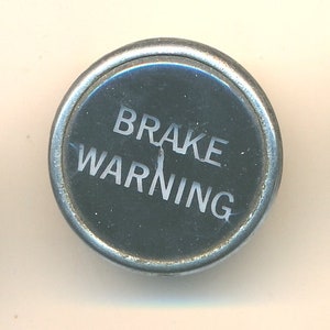 May include: Three round, silver-colored warning signs with black centers and white lettering. The signs read "Wheel Slip", "Brake Warning", and "Sand".