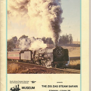 May include: A vintage poster advertising a steam train safari. The poster features a black steam locomotive with a plume of smoke rising from its chimney. The text on the poster reads "The Zig Zag Steam Safari" and "South African Transport Services".