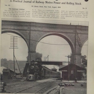 May include: A vintage black and white image of a train passing under a large stone arch bridge. The image is from the August 1899 issue of "Locomotive Engineering" magazine, featuring "The Saratoga Limited" train.
