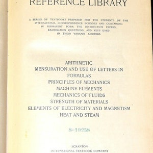 Puede incluir: Una portada de libro vintage con el título "I.C.S. Reference Library" y una lista de temas que incluyen Aritmética, Mensuración, Mecánica y Electricidad. El libro está publicado por la International Textbook Company.