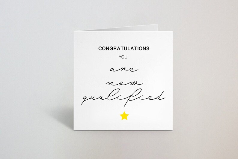 K&ouml;nnte beinhalten: Eine wei&szlig;e Gl&uuml;ckwunschkarte mit den Worten "CONGRATULATIONS YOU are now qualified" in schwarzer Schrift. Unten befindet sich ein gelber Stern. Die Karte ist gefaltet und vor einem wei&szlig;en Hintergrund platziert.