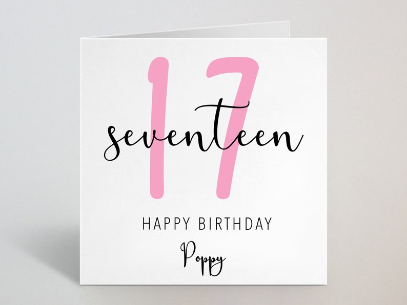May include: White birthday card with the number 17 in pink and the word "seventeen" in black script. The card also includes the text "HAPPY BIRTHDAY" and a name in script.