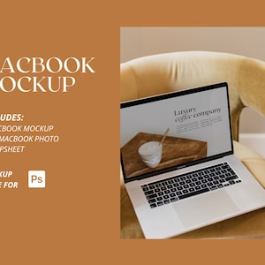 May include: A silver laptop computer with a white background on the screen. The screen displays the text "Luxury coffee company". The laptop is sitting on a beige armchair.