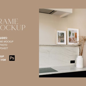 May include: Two framed photographs of nature scenes hanging on a white marble wall above a black countertop. The frames are made of natural wood and have a simple design. The photographs are of a desert landscape and a cactus garden.