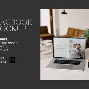 May include: A silver MacBook laptop open on a white table with a cup of coffee next to it. The laptop screen shows a website with the text "Coaching with intention" and a photo of a woman sitting on a couch using a laptop.