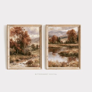 May include: Two rectangular framed wall art prints featuring landscape paintings of a river flowing through a field with autumn-colored trees and distant mountains under a cloudy sky. The text BITTERSWEET DIGITAL is printed at the bottom center.