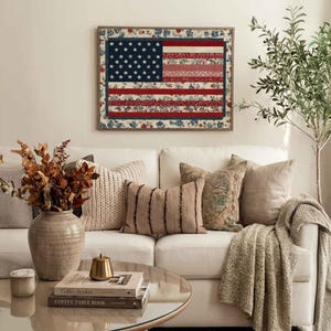 American flag quilt wall art styled above a neutral living room sofa with cozy pillows, greenery and farmhouse decor.