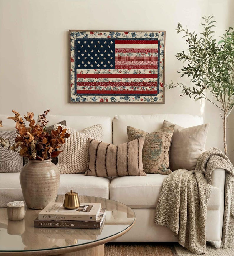 American flag quilt wall art styled above a neutral living room sofa with cozy pillows, greenery and farmhouse decor.