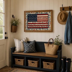 Pode incluir: Uma entrada acolhedora com um edredom emoldurado com a bandeira americana. Um banco azul escuro com tampo de madeira acomoda almofadas, cestos e uma sacola de m&atilde;o tecida. Cestos de vime s&atilde;o guardados embaixo. Um chap&eacute;u de palha e uma jaqueta jeans penduram na parede.