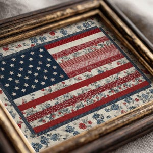 Close-up of framed American flag quilt wall art showing red, white and blue floral fabric details in a vintage gold frame.