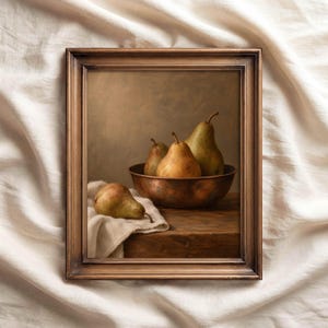 May include: A framed still life painting depicting four pears. Three pears are inside a copper-toned bowl, while one pear rests on a white cloth. The scene is set on a wooden surface with a neutral background, all enclosed in a dark bronze frame.