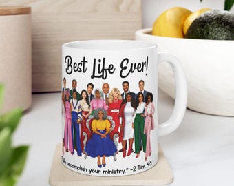 May include: A white ceramic mug featuring a colorful illustration of a diverse group of people standing together, with one person seated in a chair. The text reads Best Life Ever! and Fully accomplish your ministry. -2 Tim. 4:5 in black font.